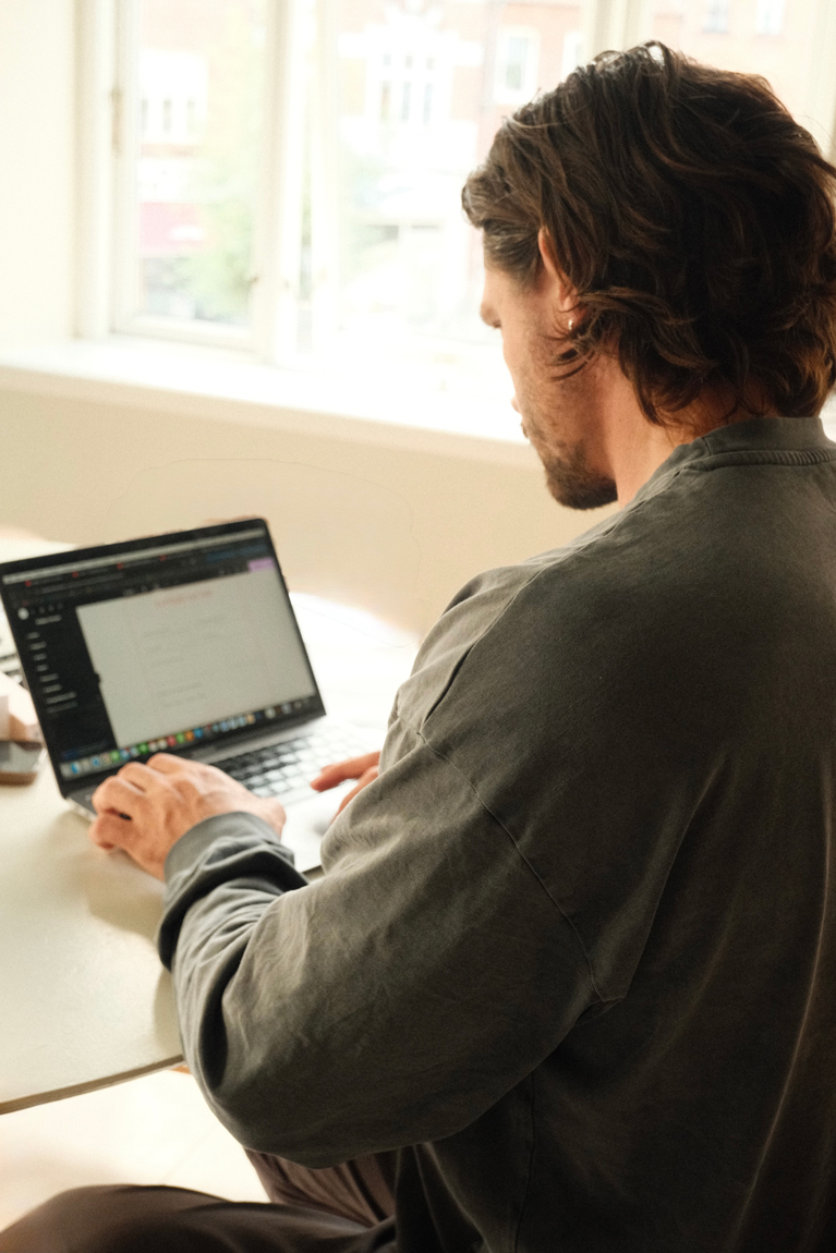 En mand sidder og laver en ny hjemmeside