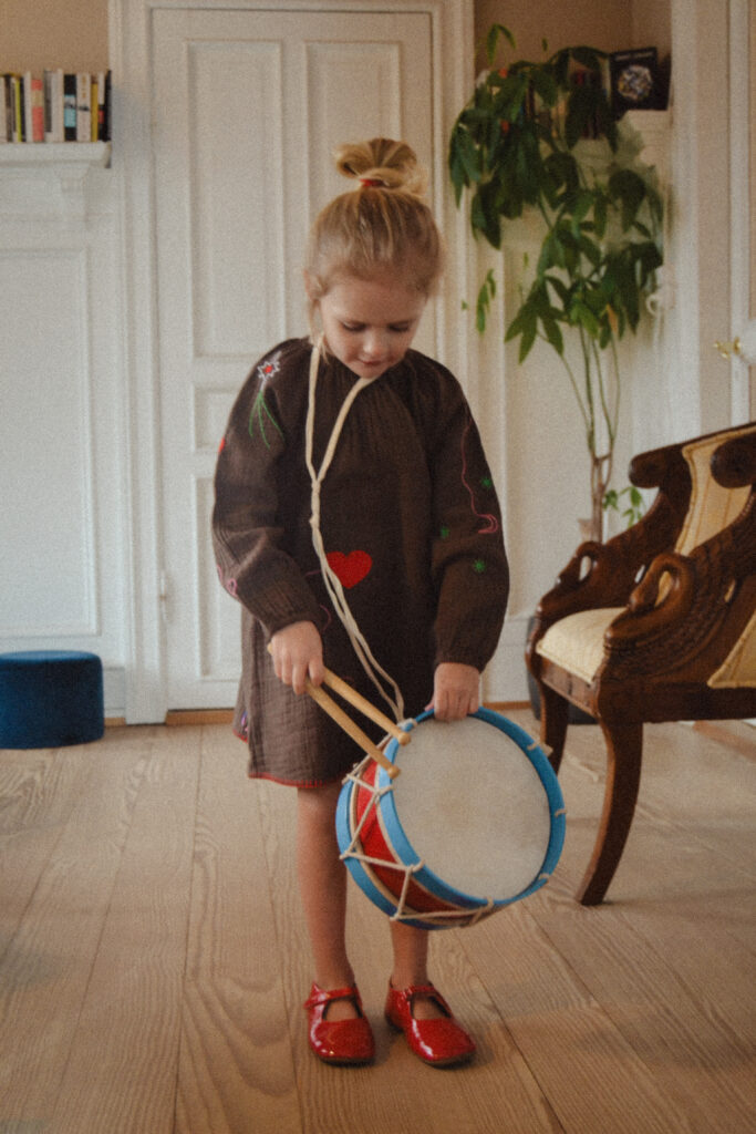 Pige går med en tromme i en Sissel Mini kjole